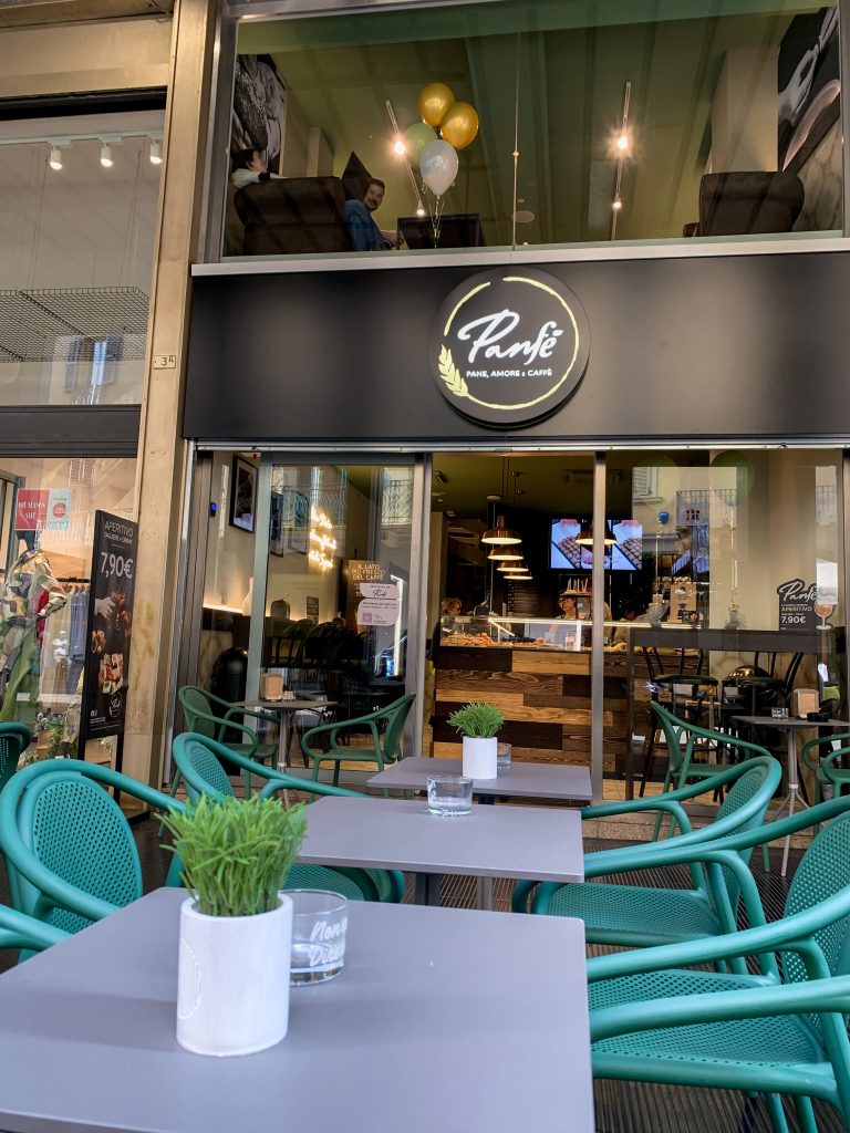 Nuova sede Panfé a Novara in Corso Italia, 5 - Dehor esterno con tavolini quadrati e sedie color verde acqua