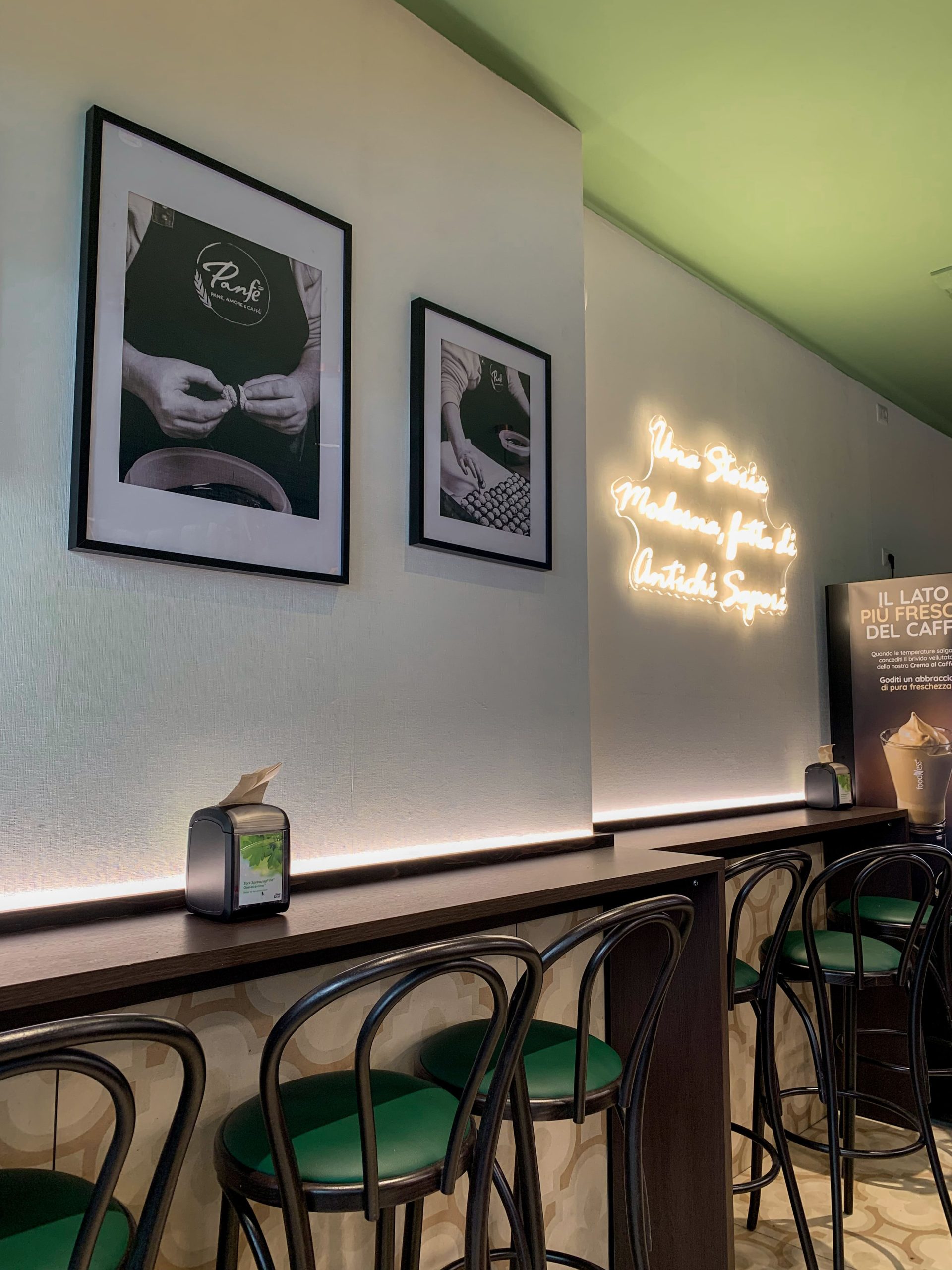 Nuova sede Panfé a Novara in Corso Italia, 5 - Interni con pareti bianche e quadri appesi con foto in bianco e nero dei volti Panfé